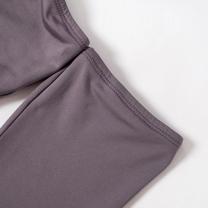 Detail view of professional double-needle stitching on dark purple yoga apparel sleeves