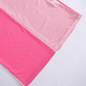 Detail der Doppelnadelnaht auf zweifarbigem rosa Netzstoff mit Pflegeetikett