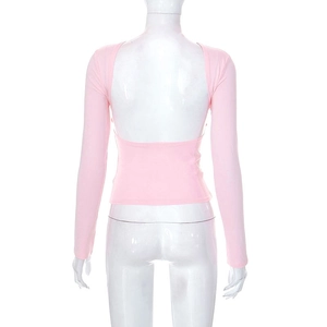 Dettaglio della maglia rosa a maniche lunghe con elegante design a schiena scoperta
