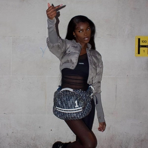 Detail of silver metallic slim jacket and mesh bodysuit with luxury crossbody bag