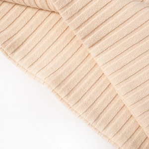 Detail of apricot rib-knit fabric texture showing soft vertical patterns and material quality