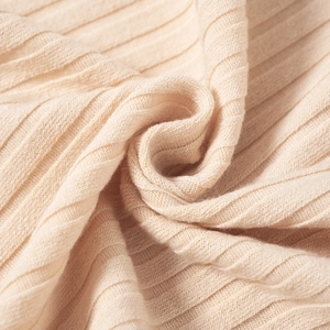 Close-up of beige ribbed knit fabric showing soft texture and premium elastic weave