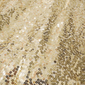 Macro shot of gold sequins on mesh fabric showing texture and metallic reflection