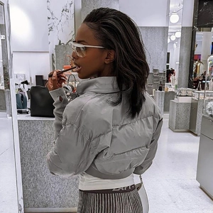 Close-up of a grey quilted puffer jacket featuring a stand collar and matte fabric finish