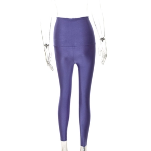 Dettaglio dei leggings viola a vita alta in tessuto lucido e orli con spacco alla caviglia