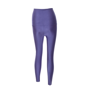 Dettaglio di leggings yoga viola a vita alta con finitura lucida e spacco alla caviglia