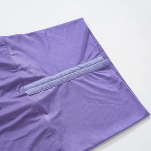 Dettaglio dei leggings viola a vita alta con chiusura a gancio e occhiello a più file