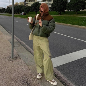 Street style shot of a two-tone padded puffer jacket paired with green cargo trousers