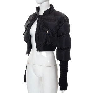 Detail of black cropped puffer jacket featuring knit sleeves and silver button pockets
