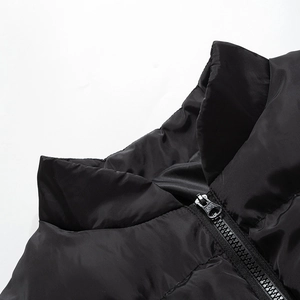 Detail shot of black shiny puffer jacket collar with metal zipper and quilting