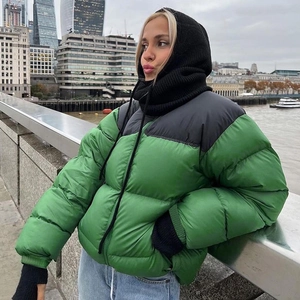 Close-up of a green puffer jacket with black shoulders and zip collar for winter fashion