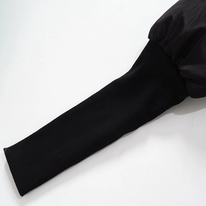 Close-up of ribbed knit cuffs and water-resistant fabric on black puffer jacket sleeves