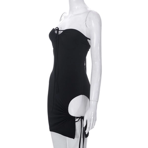 Detail van de zwarte strapless mini-jurk met cirkelvormige uitsparingen en trekkoord aan de zijkant