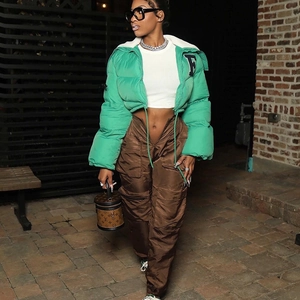 Detail of green crop puffer jacket with embroidery and brown multi-pocket cargo pants