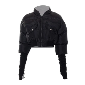 Detail of black padded jacket featuring silver snap pockets and ribbed knit sleeve cuffs