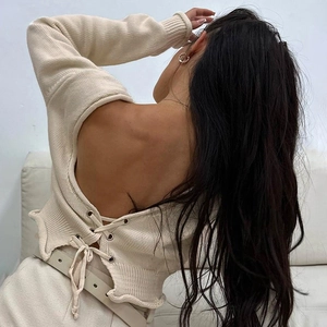 Détail du design dos nu à lacets sur un pull en maille crème avec œillets métalliques