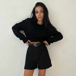 Détail d'un crop top noir à manches longues en tricot avec short taille haute et ceinture