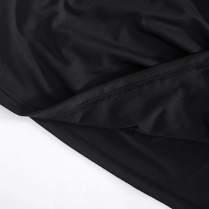 Detailopname van overlock stiksel op de zoom van een zwarte nauwsluitende jurk