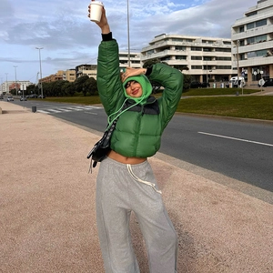 Detail of emerald green puffer jacket with black zip and matching balaclava