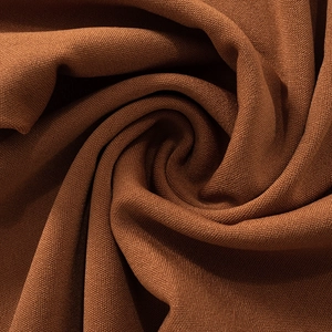 Primer plano de la textura de tela de punto marrón oscuro con pliegues elegantes y detalles