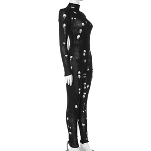 Détail d'une combinaison noire à manches longues avec des motifs tricotés ajourés créatifs