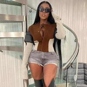 Women's color block zip-up slim fit jacket with grey denim shorts and tall black boots