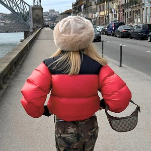 Rear view of a stylish red and black puffer jacket with camouflage pants in city setting