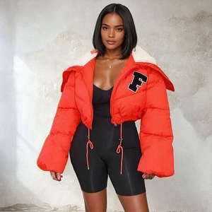 Detail view of orange puffer jacket featuring a white fur collar and F letter embroidery