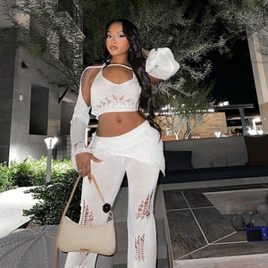 Detail of white crochet knit set featuring geometric hollow patterns and halter crop top