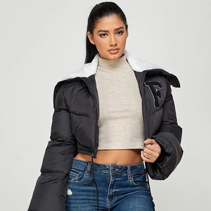 Close-up of black padded jacket featuring white faux fur collar and embroidered F letter