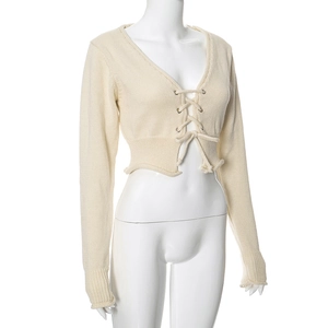 Détail du crop top en maille crème avec col en V et design à lacets sur le devant