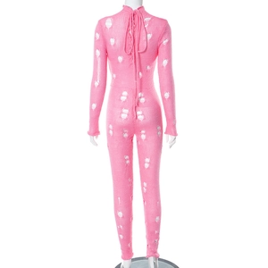 Vue arrière détaillée d'une combinaison en tricot rose avec découpes et lien à nouer
