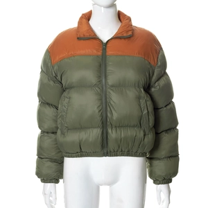 Detail of color-block puffer jacket featuring olive green and rust red with zip closure