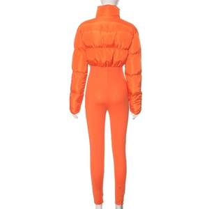 Back view of a bright orange quilted short puffer jacket and matching slim leggings outfit