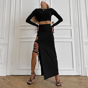 Détail d'un ensemble noir deux pièces avec haut court et jupe longue à lacets latéraux