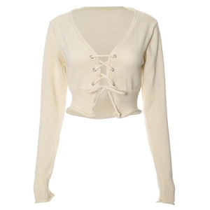 Détail du crop top en maille crème avec décolleté en V profond et lacets à œillets