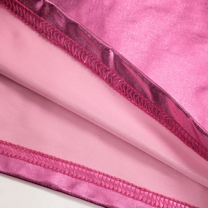 Detail of hot pink metallic fabric with precise double-needle stitching on crop top edge