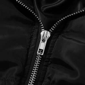 Detailed macro view of a sturdy silver metal zipper on a black glossy quilted jumpsuit
