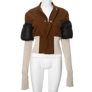 Detail of color-block jacket showing wool texture and knitted sleeves on a mannequin