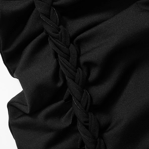 Makrodetail eines schwarzen Strickkleids mit vertikaler Flechtstruktur und feiner Verarbeitung