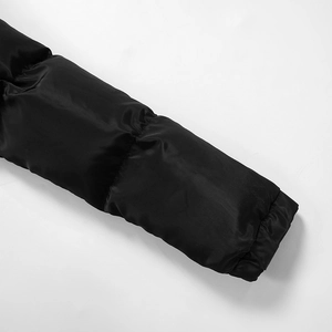 Detailed view of black quilted waterproof sleeves with horizontal stitching on a jumpsuit