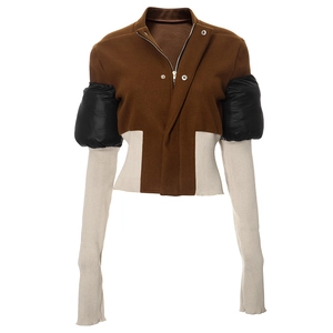 Detail of color-block jacket showing contrast between brown wool and black quilted sleeves
