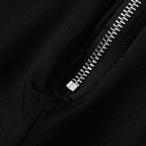 Detail of high-quality silver metal zipper and soft black knit fabric on jumpsuit