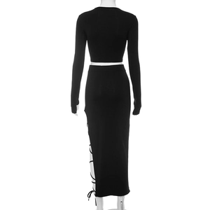 Détail d'ensemble noir deux pièces avec crop top manches longues et jupe lacée sur le côté