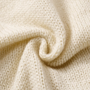 Gros plan détaillé de la texture en maille crème montrant des motifs de tissage de qualité