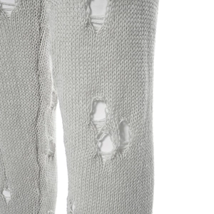 Gros plan sur un tricot gris clair montrant des détails déchirés et une texture brute