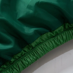 Detail of windproof dark green puffer jacket hem with elasticated ribbed texture and fine stitching