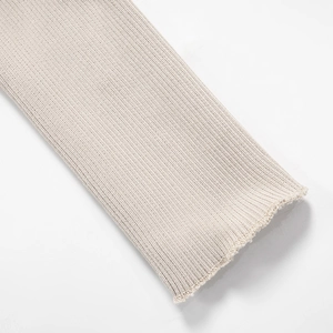 Detail of oatmeal ribbed knit sleeve cuff showing textured fiber and stitching
