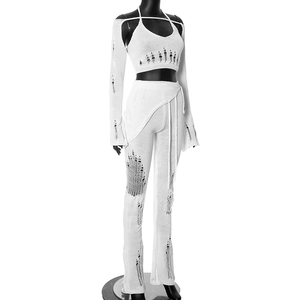 Detail of white knitted four-piece set showing artistic distressed hollow-out holes texture