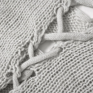 Gros plan sur le tissu en maille gris clair montrant la texture et les détails de laçage